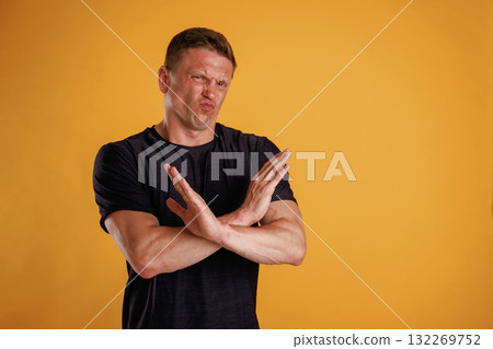 Hard dislike, showing stop or no by the hands. Man is against background in the studio Hard dislike, showing stop or no by the hands. Man is against background in the studio 132269752