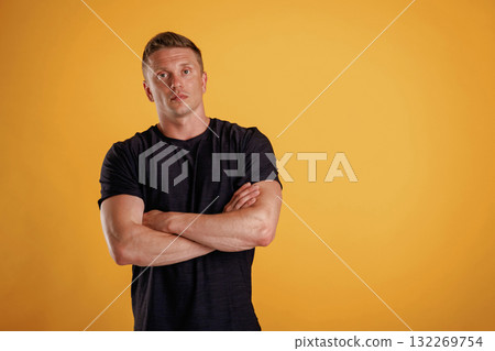 Standing with arms crossed. Man is against background in the studio 132269754