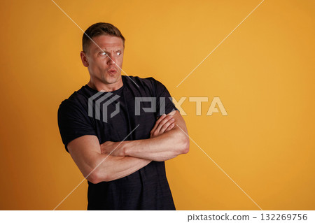 Standing with arms crossed. Man is against background in the studio 132269756