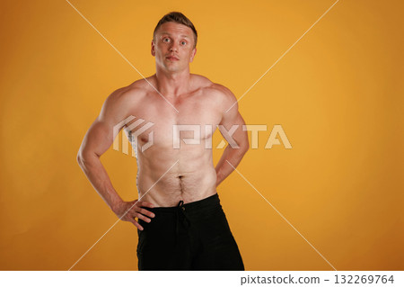 Shirtless, standing. Man is against background in the studio Shirtless, standing. Man is against background in the studio 132269764