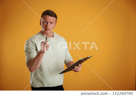 With notepad and pen. Man is against background in the studio With notepad and pen. Man is against background in the studio 132269790