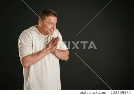 Dirty crime thoughts, rubs his hands. Man is against background in the studio 132269873