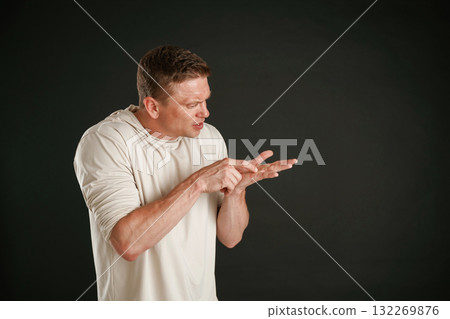 Take a look at this, copy space, showing on the palm of hand. Man is against background in the studio 132269876