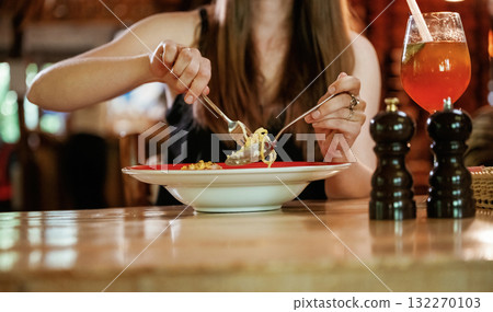 Close up view woman that is sitting in restaurant and eating food Close up view woman that is sitting in restaurant and eating food 132270103
