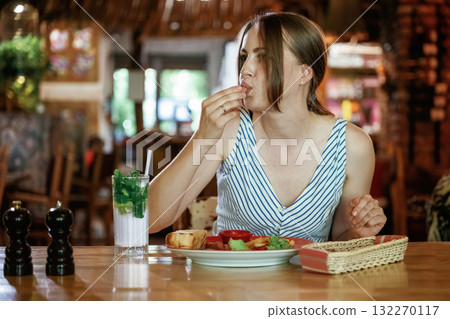 Woman is in the restaurant with food and drink Woman is in the restaurant with food and drink 132270117