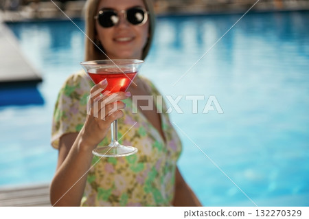 In sunglasses, with cocktail. Beautiful young woman is at resort, vacation In sunglasses, with cocktail. Beautiful young woman is at resort, vacation 132270329