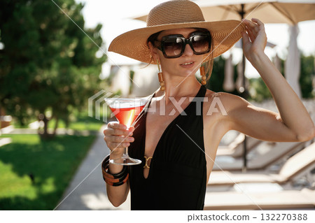 Front view, standing. Beautiful young woman is at resort, vacation 132270388