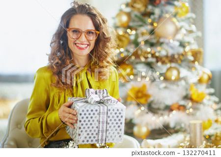 Joyful Woman with Christmas Gift and Flocked Tree Joyful Woman with Christmas Gift and Flocked Tree 132270411
