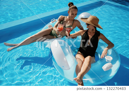 Chilling in the pool. Two beautiful women are resting Chilling in the pool. Two beautiful women are resting 132270483