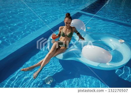On the water in the pool. Beautiful young woman is at resort, vacation On the water in the pool. Beautiful young woman is at resort, vacation 132270507