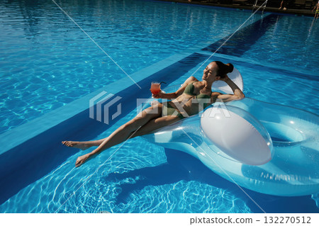 On the water in the pool. Beautiful young woman is at resort, vacation On the water in the pool. Beautiful young woman is at resort, vacation 132270512