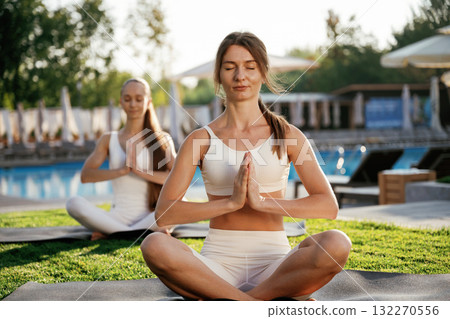 Meditation practice in lotus pose. Two fitness women are together outdoors, conception of sport 132270556