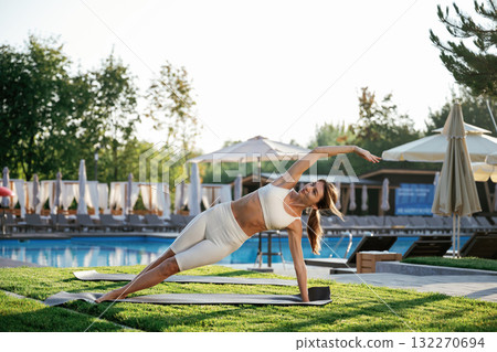 Stretching exercise. Fitness woman is outdoors, beautiful vacation place Stretching exercise. Fitness woman is outdoors, beautiful vacation place 132270694