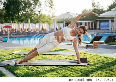 Stretching exercise. Fitness woman is outdoors, beautiful vacation place Stretching exercise. Fitness woman is outdoors, beautiful vacation place 132270695