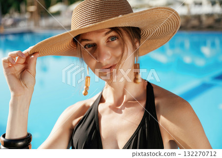 Portrait, in the straw hat. Beautiful young woman is at resort, vacation 132270712