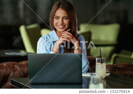 Positive facial expression. Beautiful woman with laptop is in the bar 132270814