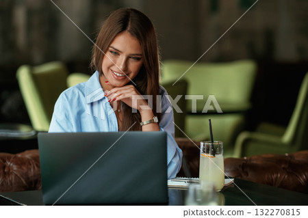 Positive facial expression. Beautiful woman with laptop is in the bar Positive facial expression. Beautiful woman with laptop is in the bar 132270815