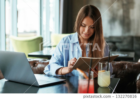 Focused at work. Beautiful woman with laptop is in the bar 132270816