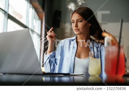 Front view. Beautiful woman with laptop is in the bar 132270836