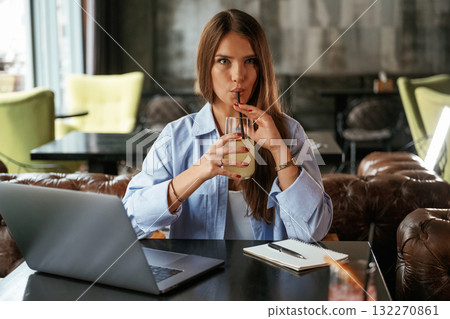 Enjoying the drink. Beautiful woman with laptop is in the bar Enjoying the drink. Beautiful woman with laptop is in the bar 132270861