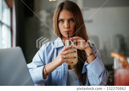 Enjoying the drink. Beautiful woman with laptop is in the bar 132270862