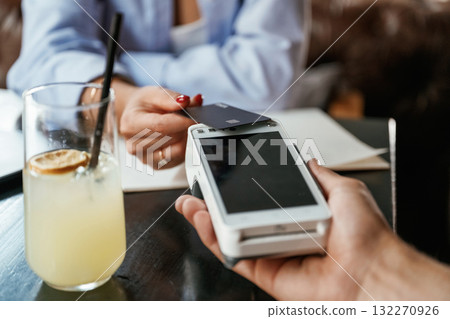 Money transfer. Woman is paying for the service in the restaurant Money transfer. Woman is paying for the service in the restaurant 132270926