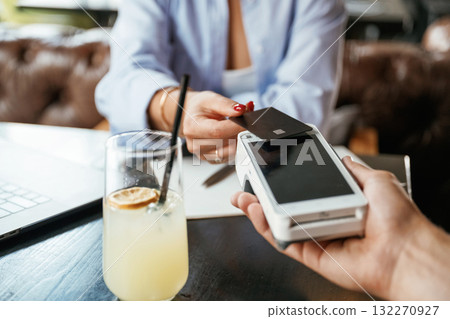 Money transfer. Woman is paying for the service in the restaurant Money transfer. Woman is paying for the service in the restaurant 132270927