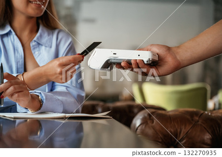 Side view. Woman is paying for the service in the restaurant Side view. Woman is paying for the service in the restaurant 132270935