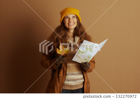 Hopeful Autumn Explorer with Map and Leaf 132270972
