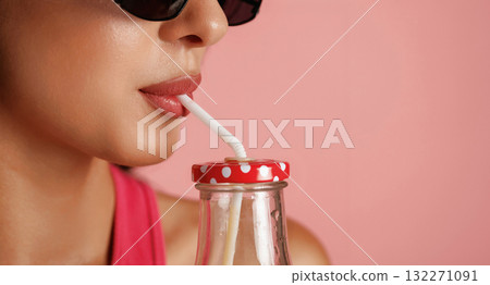 Fresh drink. Beautiful young woman is against background Fresh drink. Beautiful young woman is against background 132271091