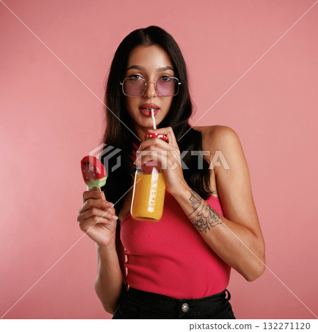 Summer fresh ice cream and orange juice. Beautiful young woman is against background Summer fresh ice cream and orange juice. Beautiful young woman is against background 132271120