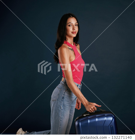 Holds a suitcase. Beautiful young woman is against background Holds a suitcase. Beautiful young woman is against background 132271140