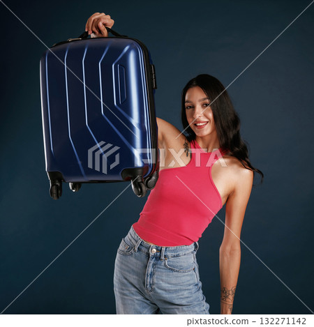 Traveling conception, with suitcase. Beautiful young woman is against background Traveling conception, with suitcase. Beautiful young woman is against background 132271142