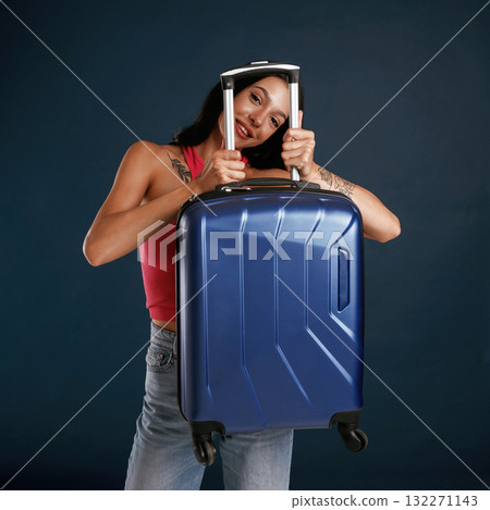 Traveling conception, with suitcase. Beautiful young woman is against background Traveling conception, with suitcase. Beautiful young woman is against background 132271143