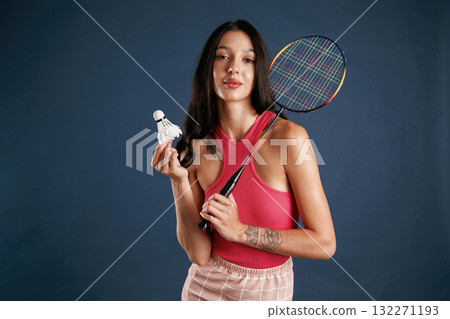 With racket for badminton sports. Beautiful young woman is against background 132271193