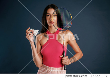 With racket for badminton sports. Beautiful young woman is against background With racket for badminton sports. Beautiful young woman is against background 132271197