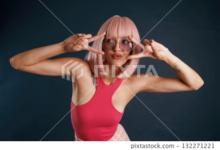 Duck face, kawaii gestures, pink hair, cute. Beautiful young woman is against background 132271221