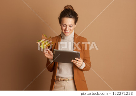 Autumnal Tech User with Leaves and Digital Tablet 132271238