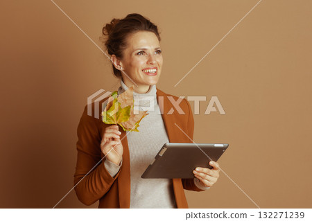 Optimistic Woman Contemplating with Tablet and Leaves 132271239