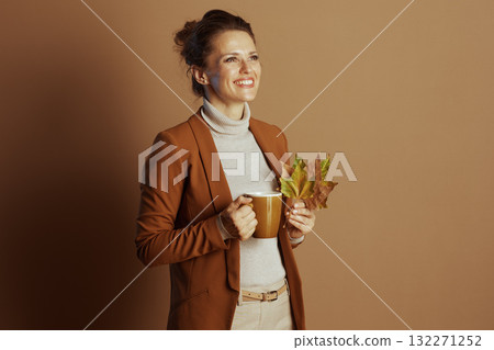 Happy Businesswoman Enjoys Autumn Mug and Leaves 132271252