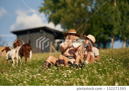 Tasty fresh milk, drinking. Mother and daughter are together on the farm with goats 132271393