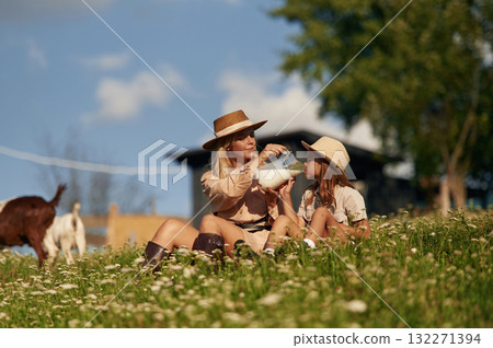 Tasty fresh milk, drinking. Mother and daughter are together on the farm with goats 132271394