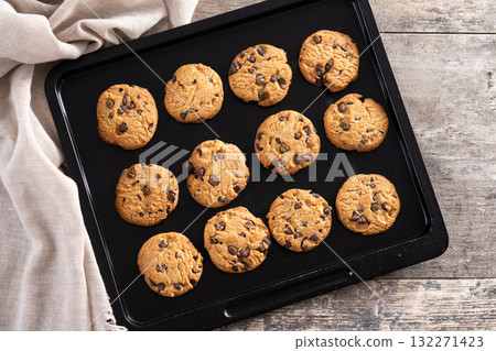 Baked chocolate chip cookies on a black baking tray 132271423