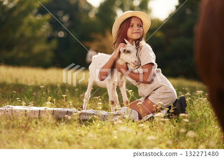 Little girl is on the field with goats Little girl is on the field with goats 132271480