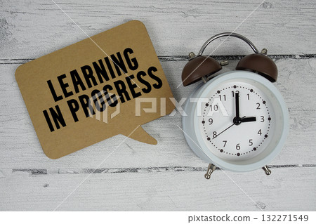 Learning in progress text with alarm clock on wooden background 132271549