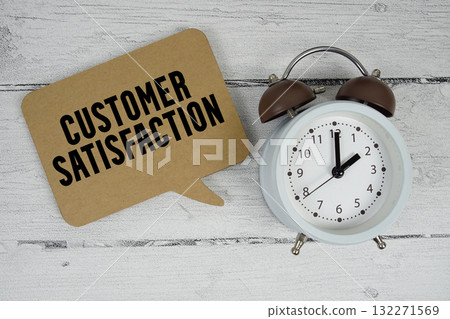 Customer satisfaction text with alarm clock on wooden background 132271569