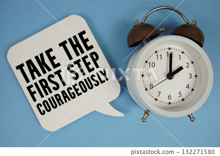 Take the first step courageously text with alarm clock on blue background Take the first step courageously text with alarm clock on blue background 132271580