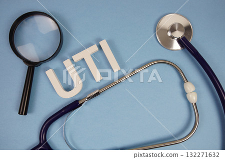 UTI abbreviation of Urinary Tract Infection alphabet letters with magnifying glass and stethoscope on blue background UTI abbreviation of Urinary Tract Infection alphabet letters with magnifying glass and stethoscope on blue background 132271632