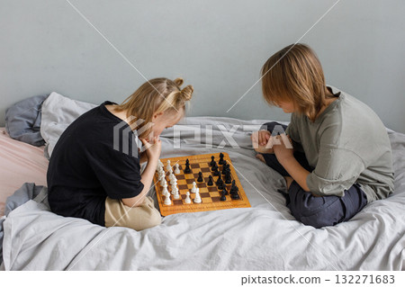 Thinking boy and girl playing chess board game while thinking of move with knowledge Thinking boy and girl playing chess board game while thinking of move with knowledge 132271683