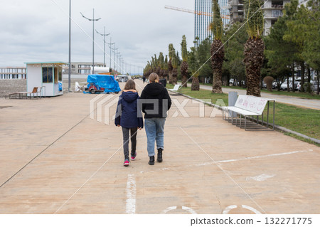 Back of young girls in season jacket walking down outdoors 132271775